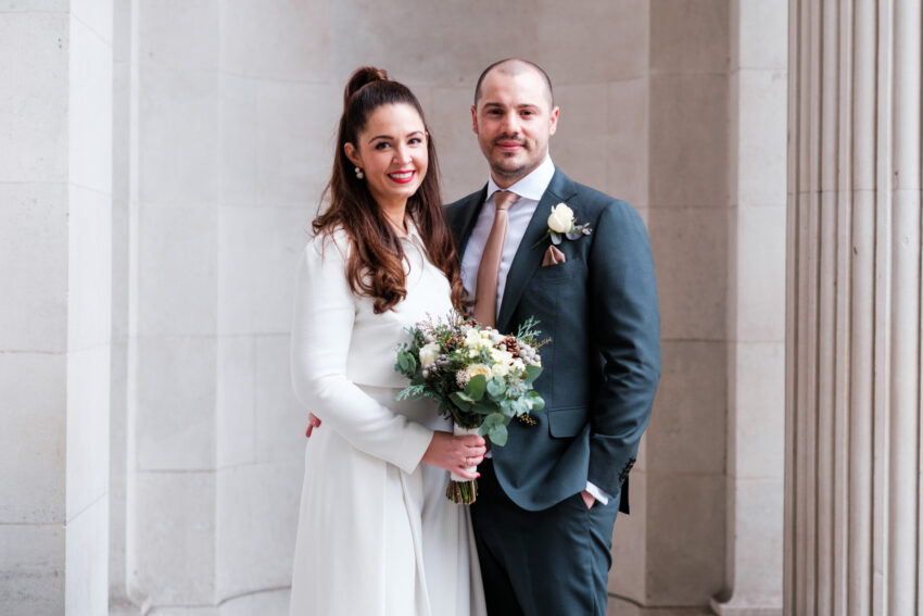 Newly married couple posing for a portrait outside Old Marylebone Town Hall.