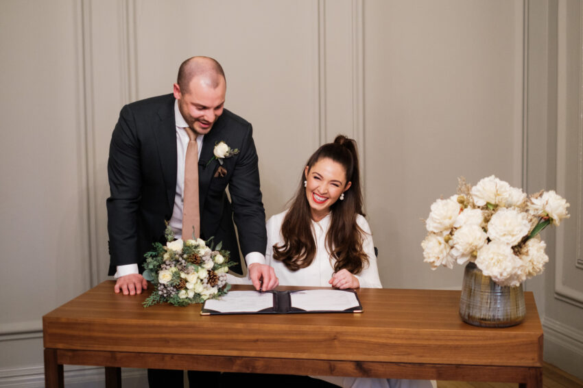 Bride signing the wedding register in the Pimlico Room at Old Marylebone Town Hall.