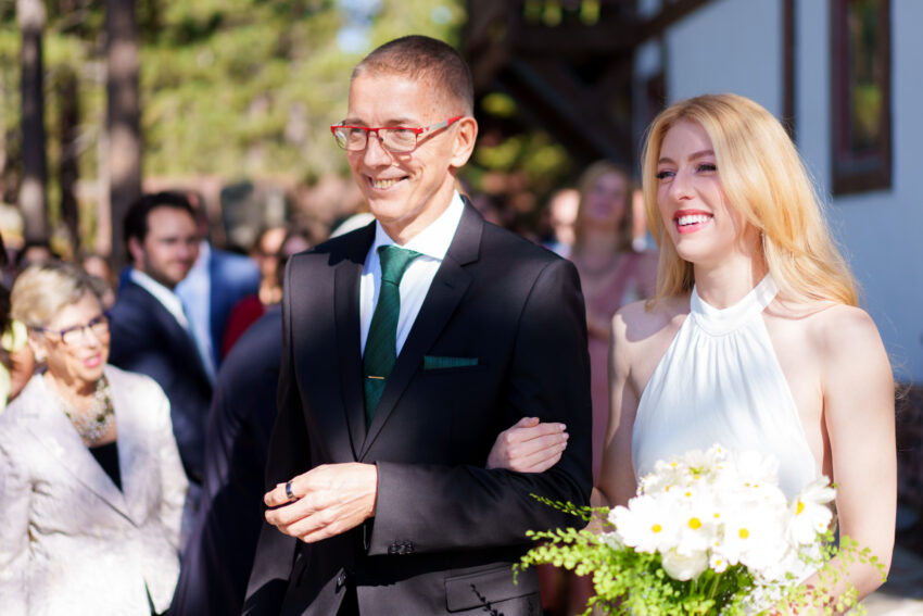 Groom walking with the bride as they arrive at the ceremony overlooking Lake Tahoe.