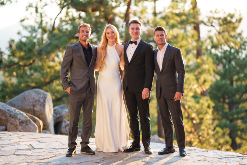 Bride and groom posing with groomsmen during golden hour portraits overlooking Lake Tahoe.