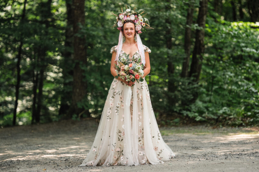 Bride standing in the woodland with floral crown and bouquet at Trillium Resort & Spa in Muskoka.