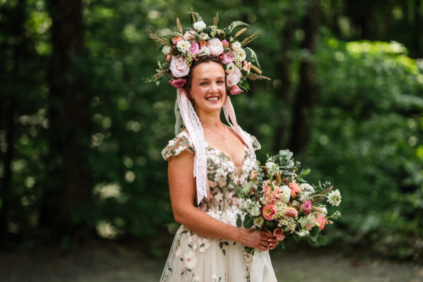 Bride smiling with bouquet and flower crown in the forest at Trillium Resort & Spa.