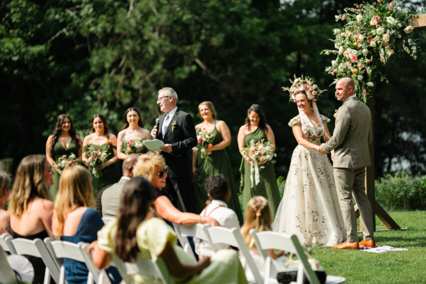 Bride and groom standing with the officiant during their outdoor ceremony at Trillium Resort & Spa in Muskoka.