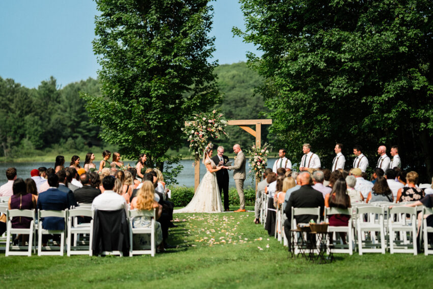 Wide view of guests watching the ceremony beside the lake at Trillium Resort & Spa in Muskoka, Ontario.