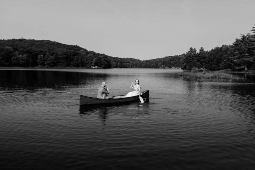Black and white photo of the bride and groom in a canoe on the lake at Trillium Resort & Spa.