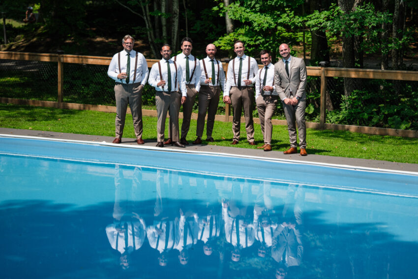 Groomsmen standing beside the swimming pool at Trillium Resort & Spa in Muskoka, Ontario.