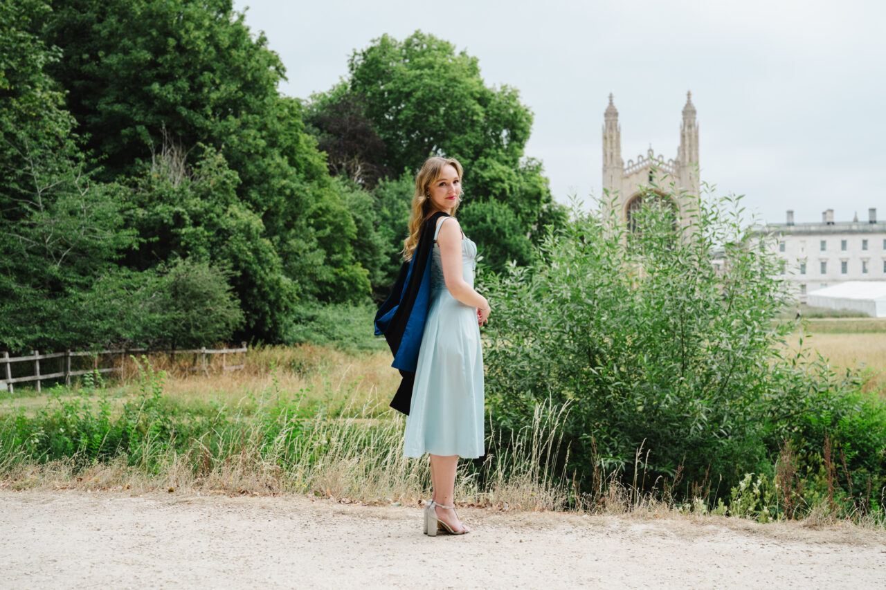 Cambridge graduation portrait in graduation gown overlooking King's College Chapel from The Backs